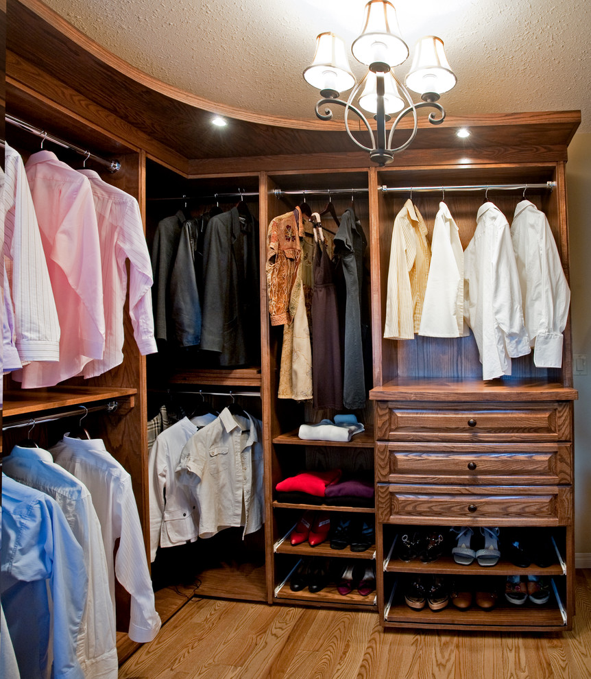 Large elegant men's medium tone wood floor walk-in closet photo in Calgary with raised-panel cabinets and medium tone wood cabinets