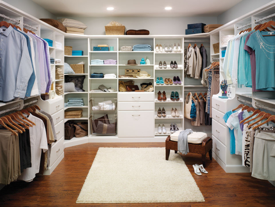 Diseño de armario vestidor unisex minimalista grande con armarios abiertos, puertas de armario blancas y suelo de madera en tonos medios