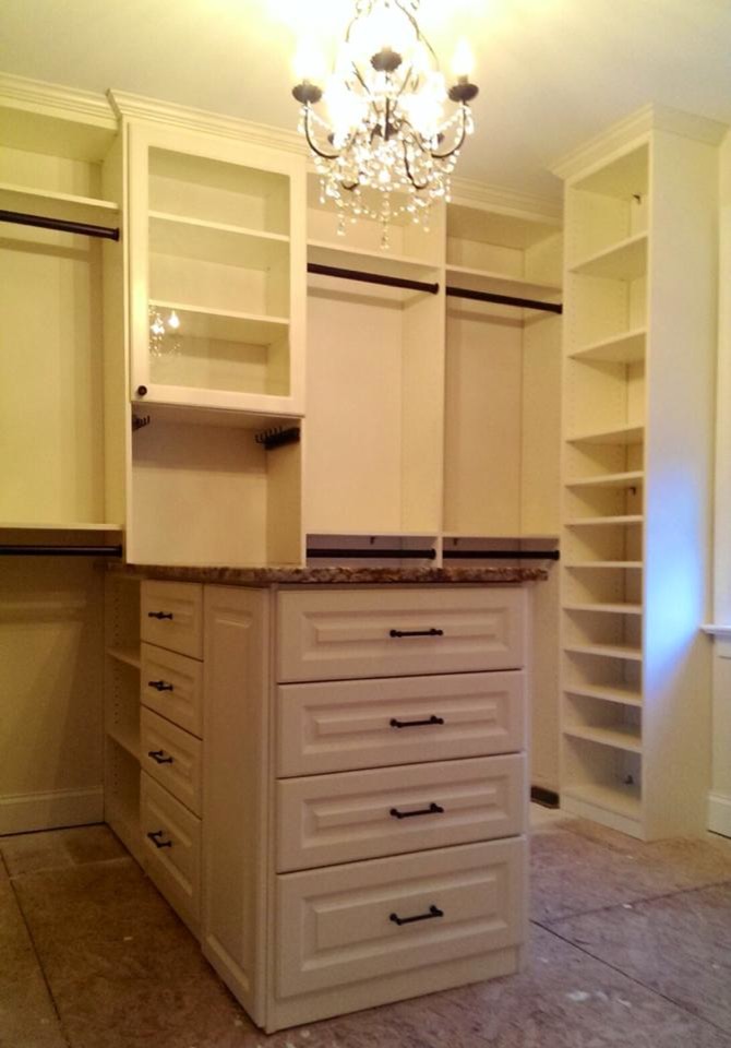Foto de armario vestidor unisex grande con armarios con paneles con relieve, puertas de armario blancas y suelo de contrachapado