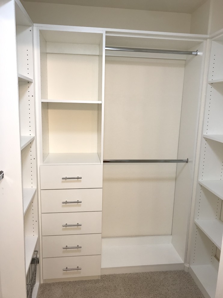 Cette image montre un dressing minimaliste de taille moyenne et neutre avec des portes de placard blanches, moquette et un sol gris.