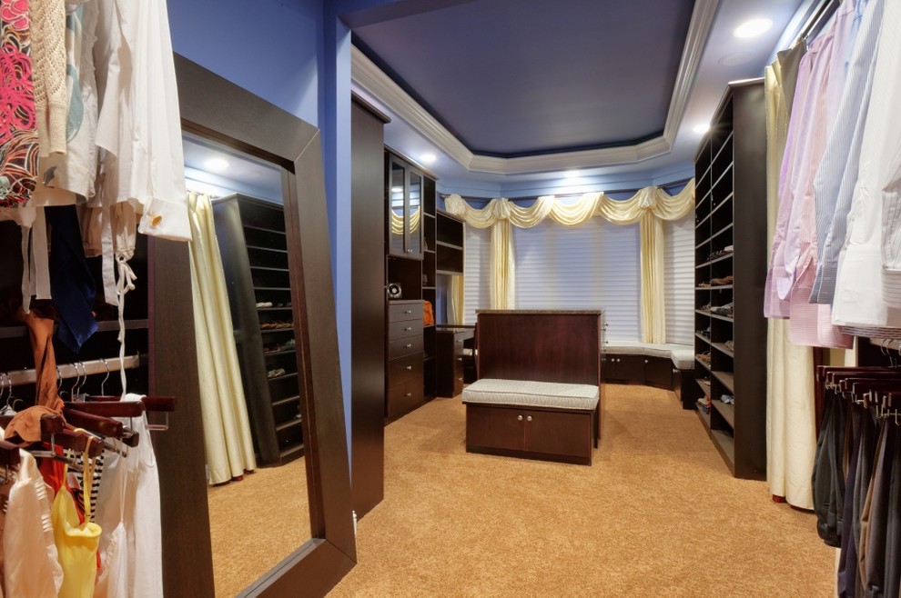 Imagen de armario vestidor contemporáneo extra grande con armarios con paneles lisos, puertas de armario de madera en tonos medios y moqueta