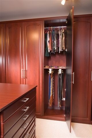 Inspiration for a large timeless gender-neutral carpeted walk-in closet remodel in Chicago with raised-panel cabinets and dark wood cabinets