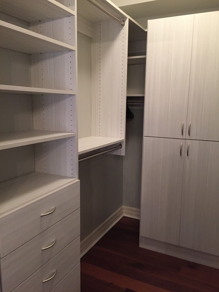Photo of a medium sized modern gender neutral walk-in wardrobe in Miami with flat-panel cabinets, light wood cabinets and medium hardwood flooring.