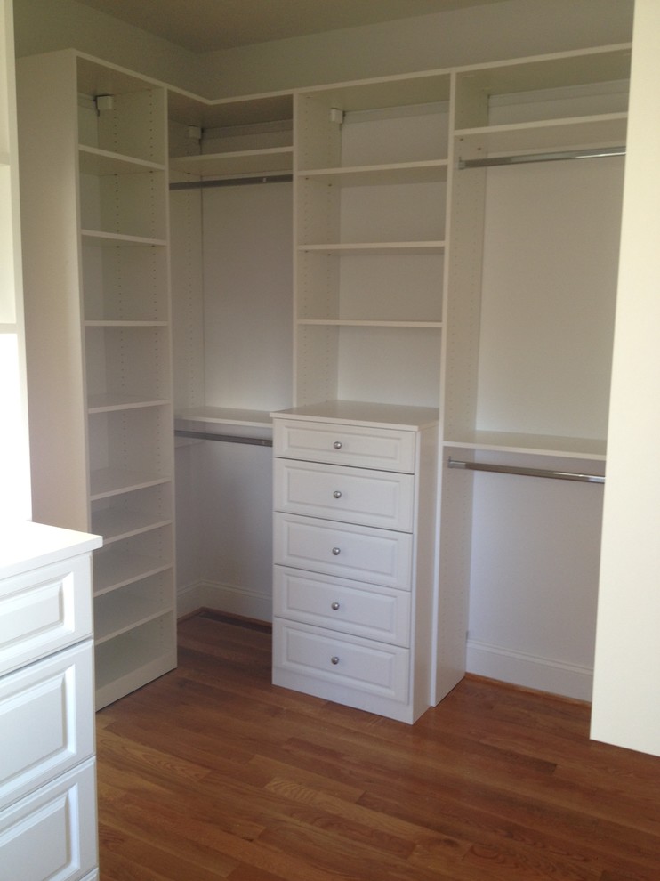 Design ideas for a medium sized traditional gender neutral walk-in wardrobe in Charlotte with raised-panel cabinets, white cabinets, medium hardwood flooring and brown floors.