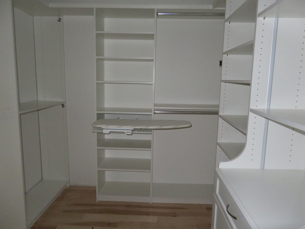 Foto de armario vestidor unisex tradicional renovado pequeño con armarios abiertos, puertas de armario blancas, suelo de madera clara y suelo beige