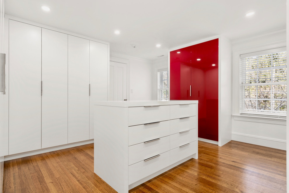 Идея дизайна: гардеробная комната унисекс в современном стиле с красными фасадами и паркетным полом среднего тона