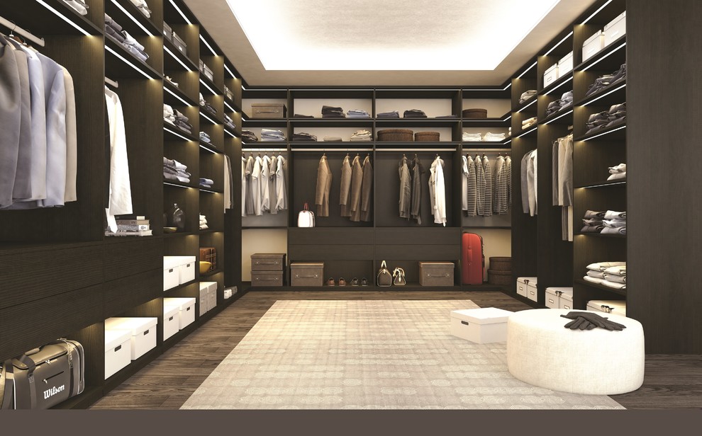 Diseño de armario vestidor unisex moderno grande con armarios con paneles lisos, puertas de armario de madera en tonos medios, suelo de madera oscura y suelo marrón