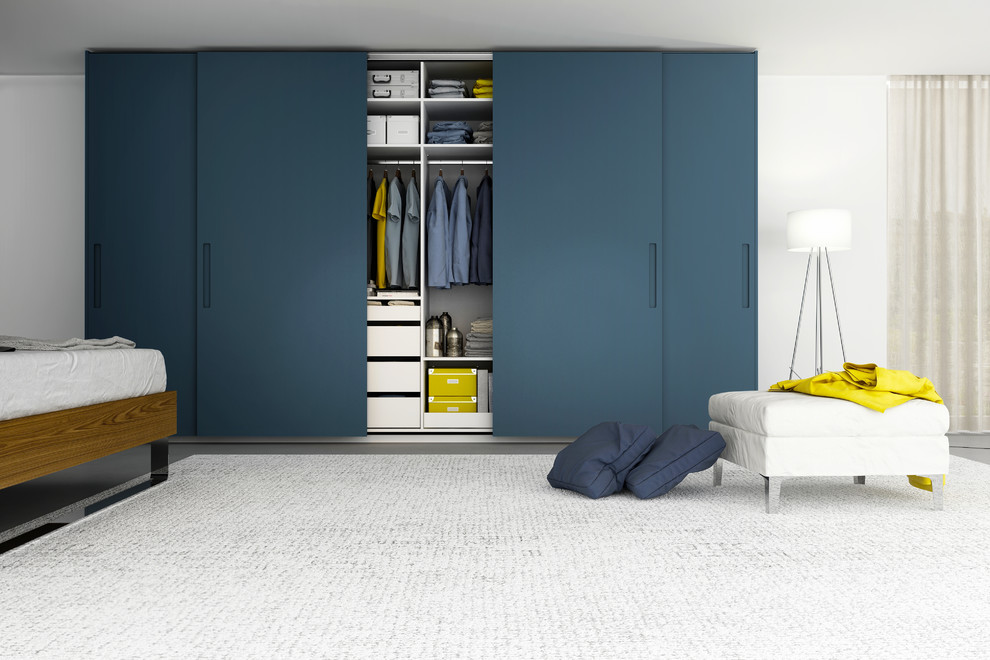 Imagen de armario unisex minimalista grande con armarios con paneles lisos y puertas de armario de madera oscura