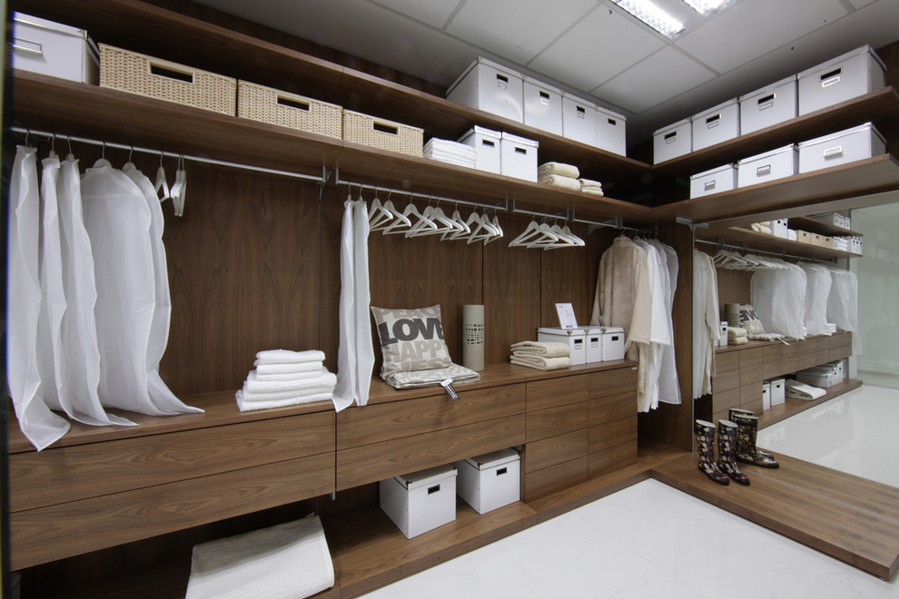 Foto di una grande cabina armadio unisex minimalista con ante lisce e ante in legno scuro