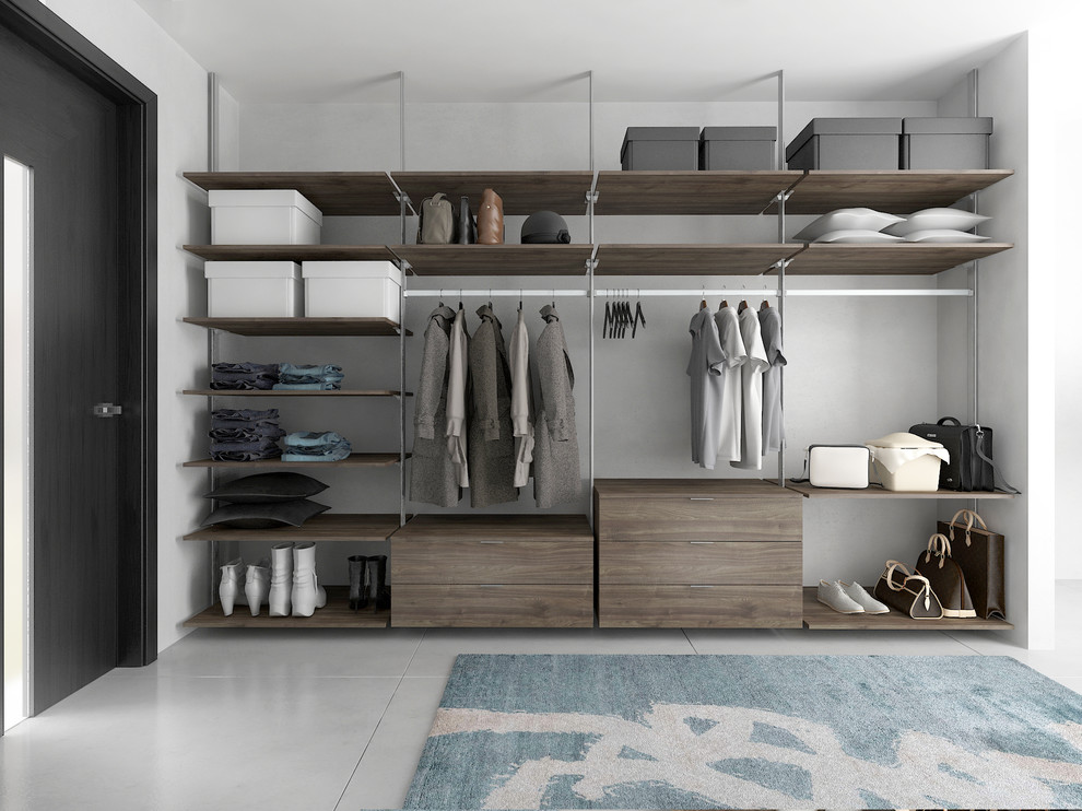 Ejemplo de armario vestidor unisex minimalista grande con armarios con paneles lisos, puertas de armario de madera oscura, suelo de baldosas de cerámica y suelo gris