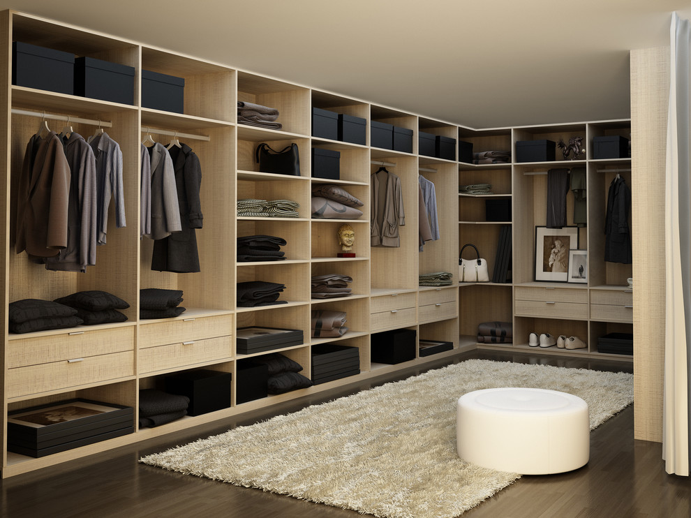 Diseño de armario vestidor unisex moderno grande con armarios con paneles lisos, puertas de armario de madera clara y suelo de madera oscura