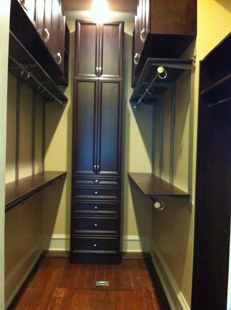 Inspiration for a timeless gender-neutral medium tone wood floor walk-in closet remodel in Birmingham with open cabinets and dark wood cabinets