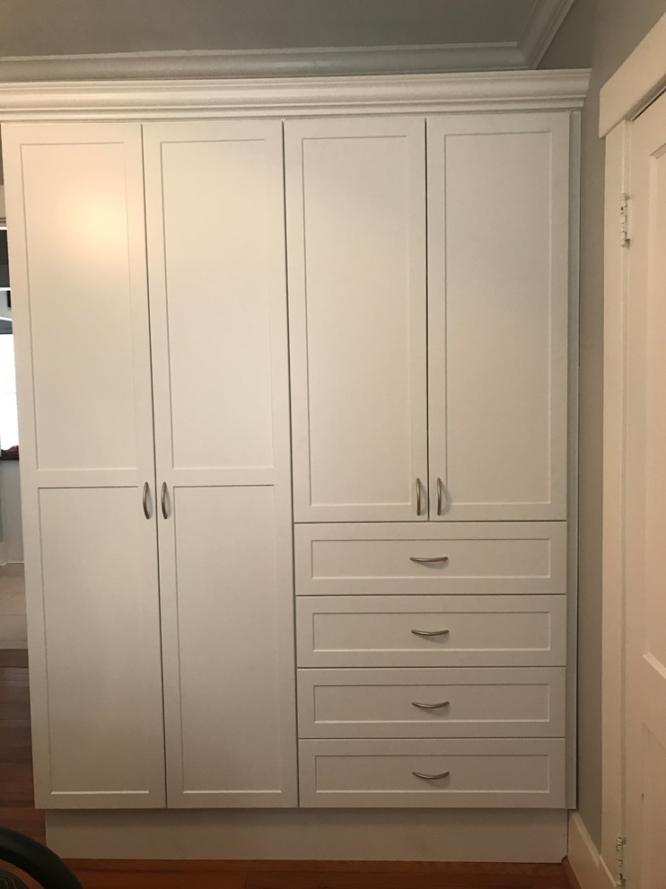 Foto de armario unisex contemporáneo de tamaño medio con armarios con paneles empotrados, puertas de armario grises y suelo de madera en tonos medios