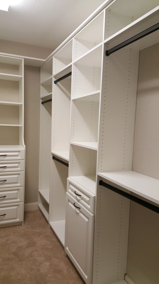 Bild på ett mellanstort funkis walk-in-closet för könsneutrala, med luckor med upphöjd panel och vita skåp