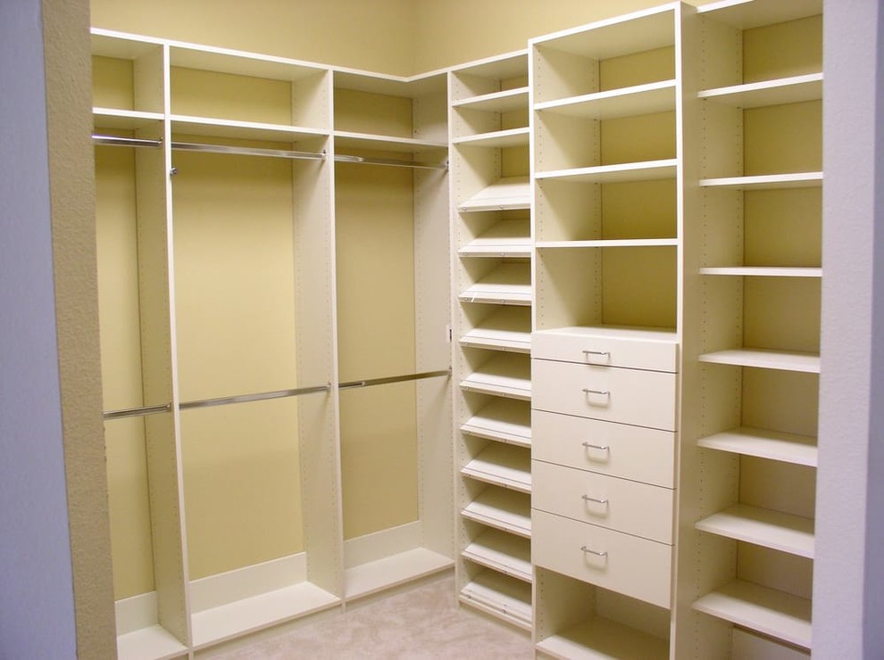 Aménagement d'un dressing classique de taille moyenne et neutre avec un placard sans porte, des portes de placard blanches, moquette et un sol beige.