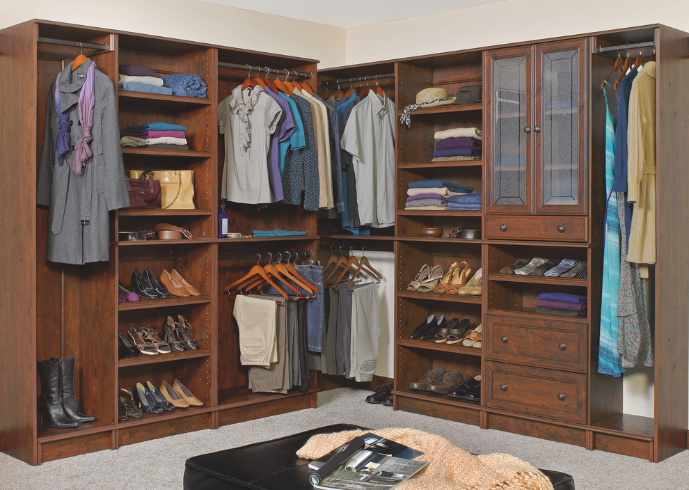 Photo of a large traditional gender neutral dressing room in Other with recessed-panel cabinets, dark wood cabinets, carpet and grey floors.