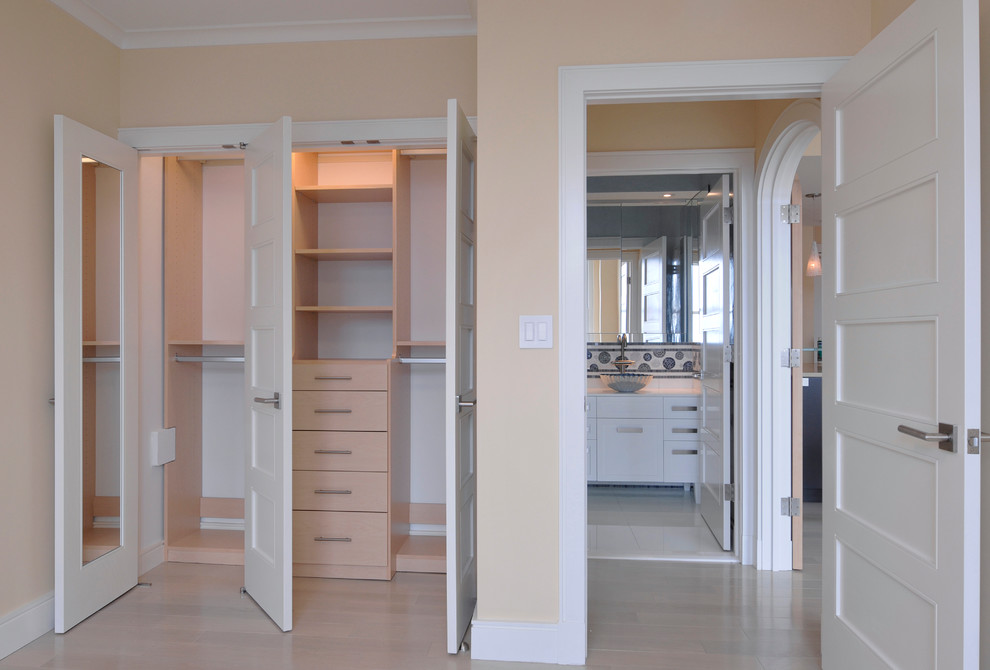 Inspiration for a small wardrobe in New York with flat-panel cabinets, light wood cabinets and light hardwood flooring.