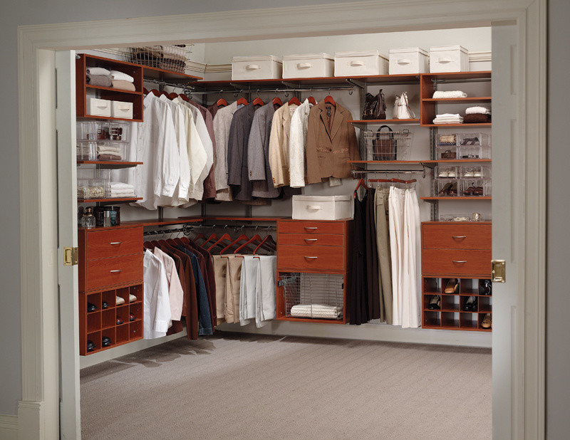 Diseño de armario vestidor unisex tradicional grande con armarios con paneles lisos, puertas de armario de madera en tonos medios, moqueta y suelo gris