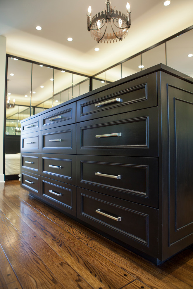Example of a large transitional gender-neutral light wood floor walk-in closet design in Los Angeles with recessed-panel cabinets and dark wood cabinets