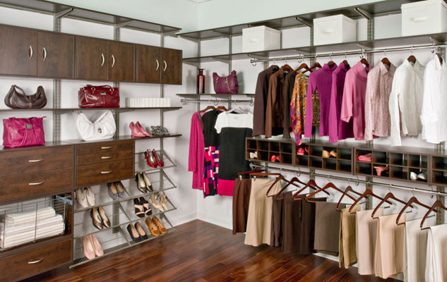 Example of a large women's medium tone wood floor walk-in closet design in Raleigh with dark wood cabinets