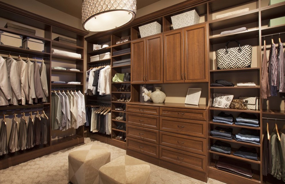 Inspiration for a large transitional gender-neutral carpeted and beige floor walk-in closet remodel in Calgary with shaker cabinets and dark wood cabinets