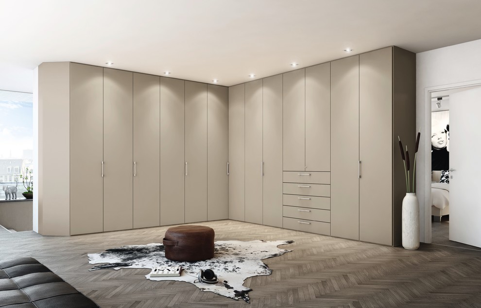 Geräumiges, Neutrales Modernes Ankleidezimmer mit Ankleidebereich, flächenbündigen Schrankfronten, beigen Schränken und dunklem Holzboden in Detroit