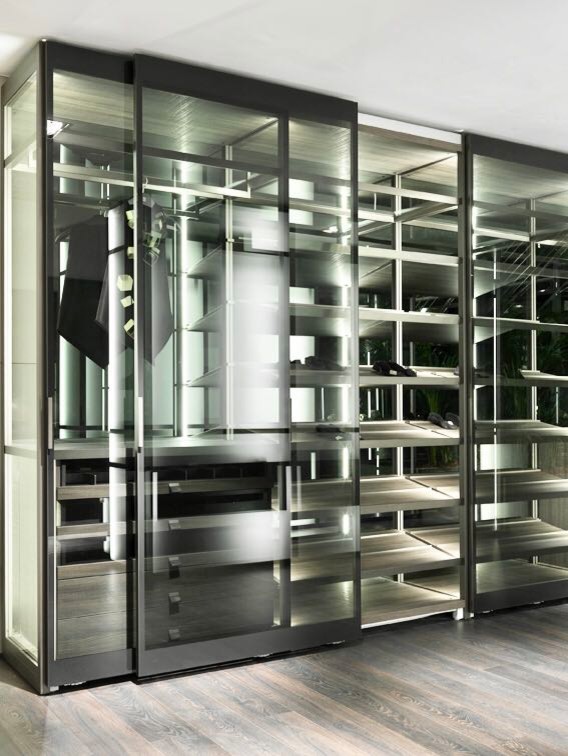 Diseño de armario vestidor unisex contemporáneo grande con armarios con paneles lisos, puertas de armario marrones, suelo de madera en tonos medios y suelo gris