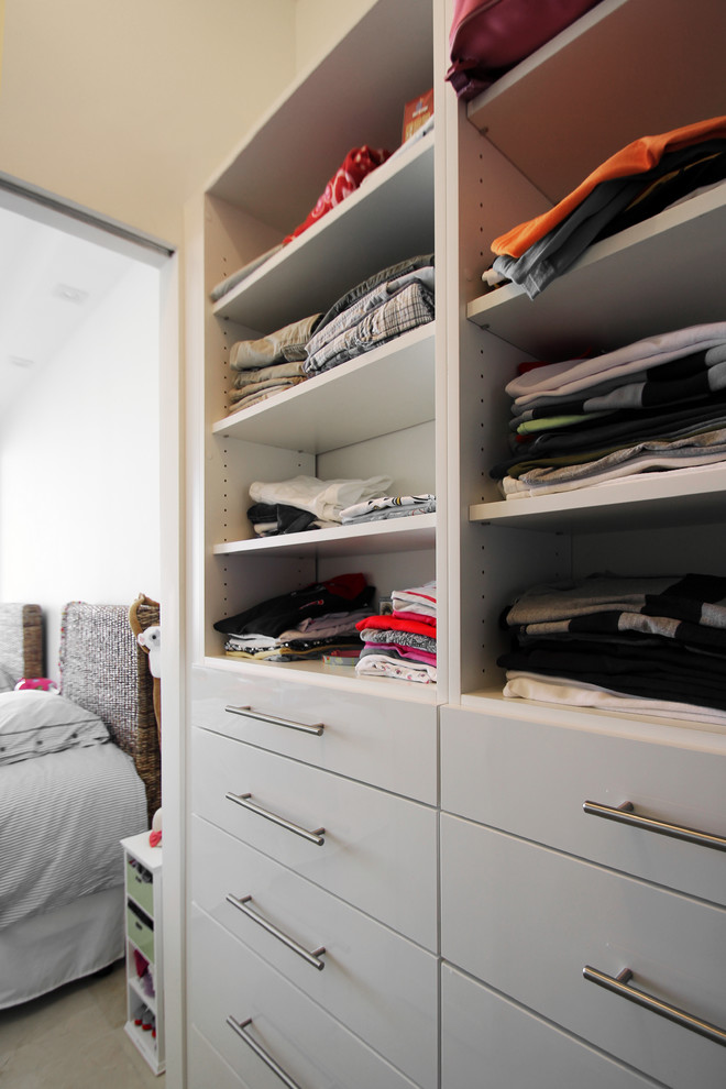 Photo of a small contemporary walk-in wardrobe in Miami with flat-panel cabinets, white cabinets, porcelain flooring and beige floors.