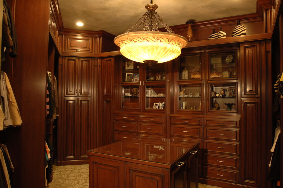 Inspiration for a large timeless gender-neutral walk-in closet remodel in Houston with medium tone wood cabinets