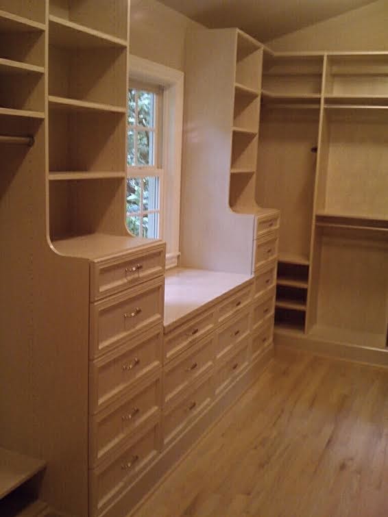 Inspiration for a large contemporary gender neutral walk-in wardrobe in Seattle with recessed-panel cabinets, white cabinets, light hardwood flooring and beige floors.