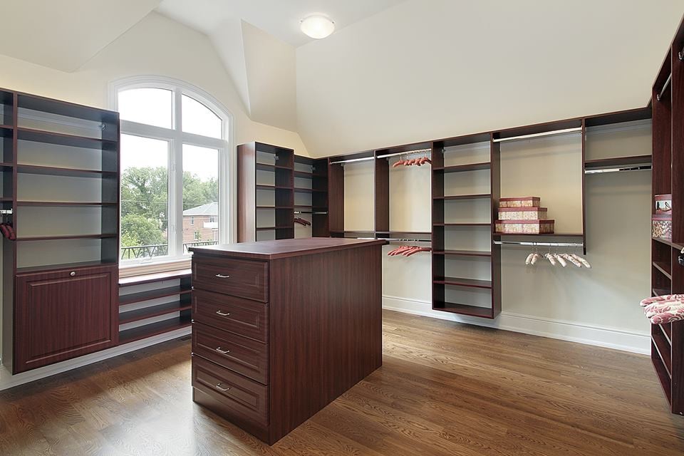 Inspiration for a mid-sized timeless gender-neutral light wood floor dressing room remodel in New York with dark wood cabinets and open cabinets