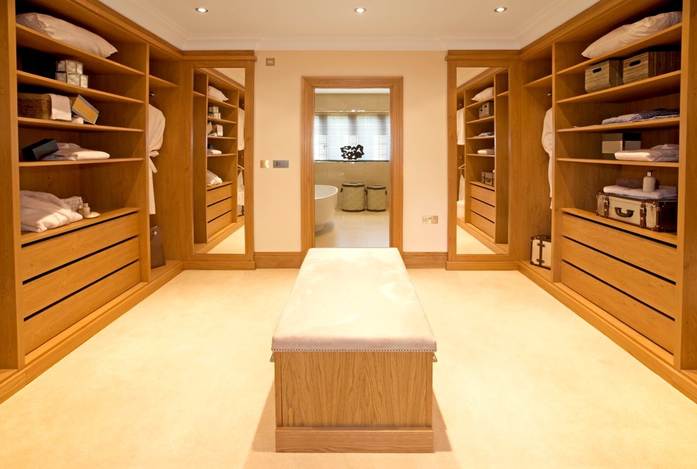 Diseño de armario vestidor unisex clásico renovado grande con puertas de armario de madera clara, moqueta, suelo beige y armarios con paneles lisos