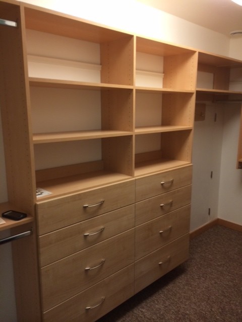 Medium sized modern gender neutral walk-in wardrobe in Other with flat-panel cabinets, light wood cabinets and carpet.