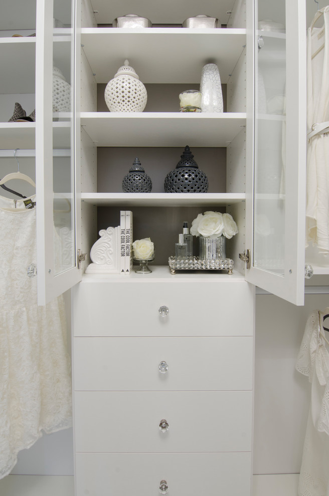This is an example of a large contemporary gender neutral walk-in wardrobe in Calgary with flat-panel cabinets, white cabinets, marble flooring and white floors.