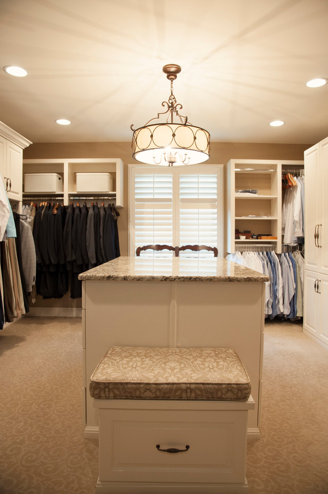 Ejemplo de armario vestidor tradicional renovado grande con armarios con paneles con relieve y puertas de armario blancas