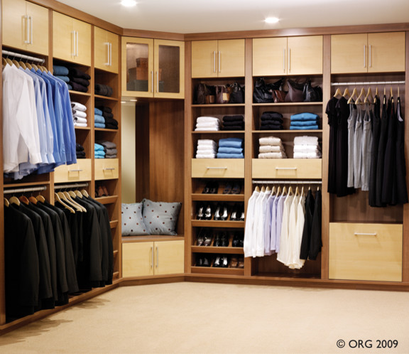 Imagen de armario vestidor unisex clásico grande con armarios con paneles lisos, puertas de armario de madera oscura, moqueta y suelo beige