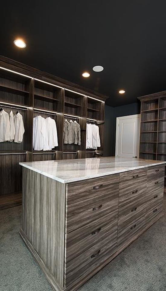 Exempel på ett stort klassiskt omklädningsrum för män, med släta luckor, skåp i mörkt trä, heltäckningsmatta och grått golv