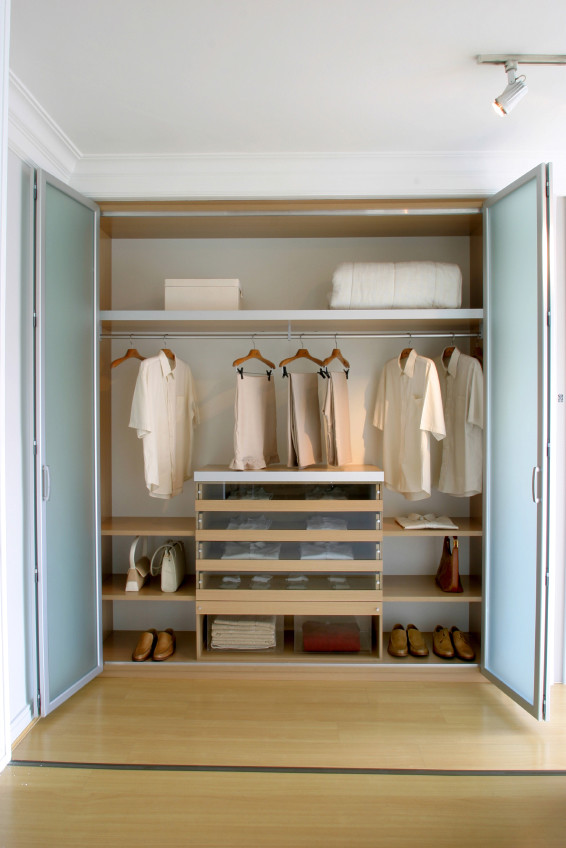 Modelo de armario unisex minimalista pequeño con armarios tipo vitrina, puertas de armario de madera clara y suelo de madera clara