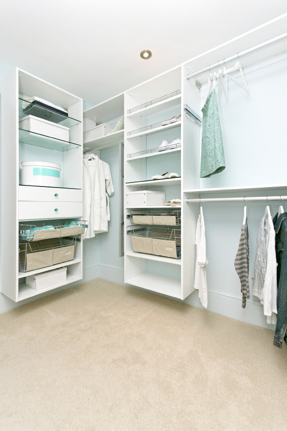 Diseño de armario vestidor unisex actual de tamaño medio con armarios con paneles lisos, puertas de armario blancas y moqueta