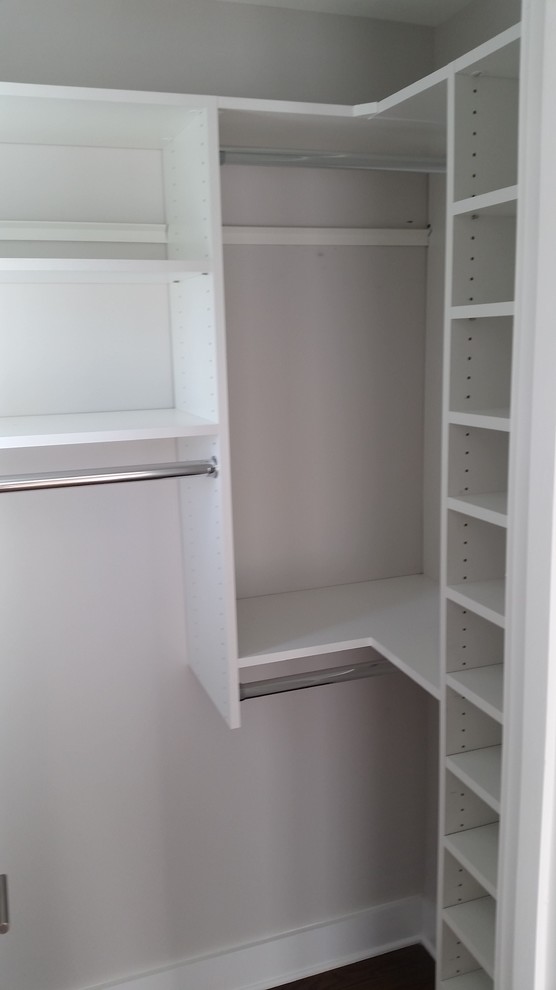 Imagen de armario vestidor unisex actual grande con armarios abiertos, puertas de armario blancas, suelo de madera clara y suelo marrón