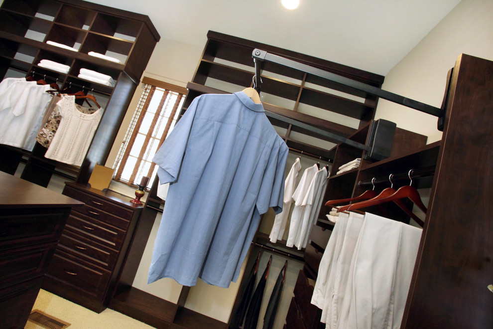 Modelo de vestidor unisex clásico grande con armarios con rebordes decorativos y puertas de armario de madera en tonos medios