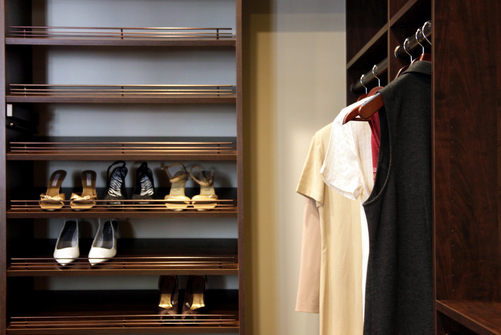 Design ideas for a medium sized modern walk-in wardrobe for women in Dallas with dark wood cabinets.