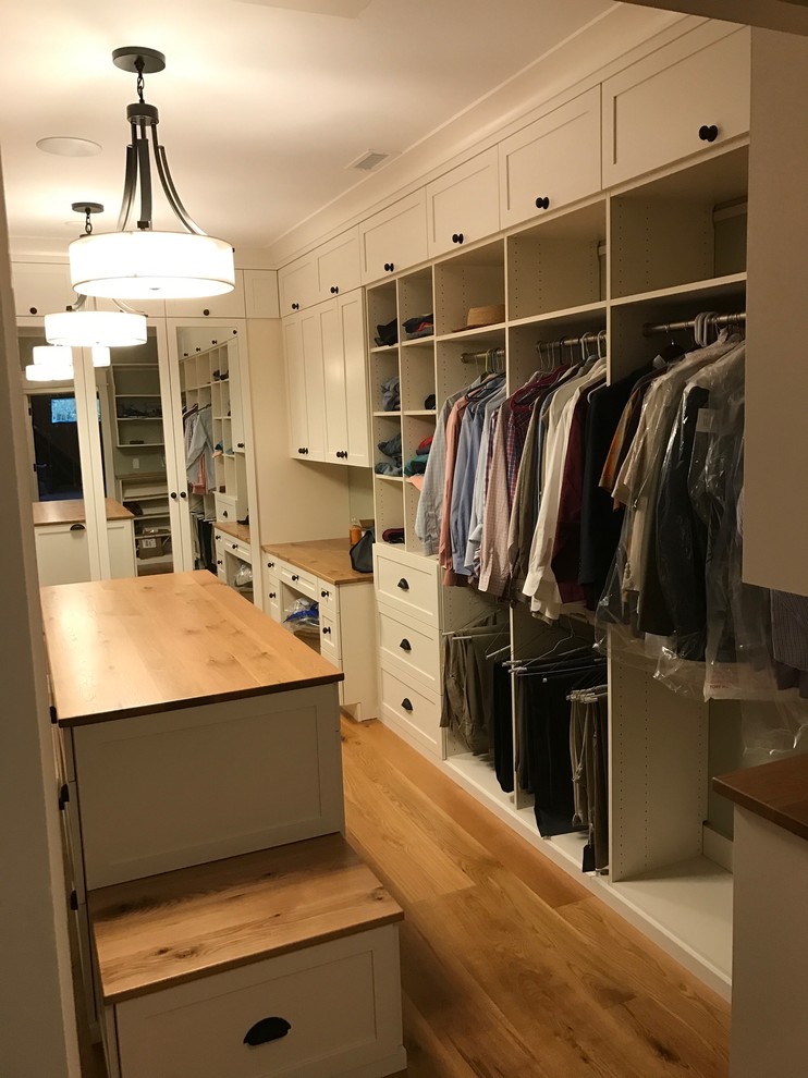 Inspiration for a country gender neutral walk-in wardrobe in Providence with shaker cabinets, white cabinets and medium hardwood flooring.