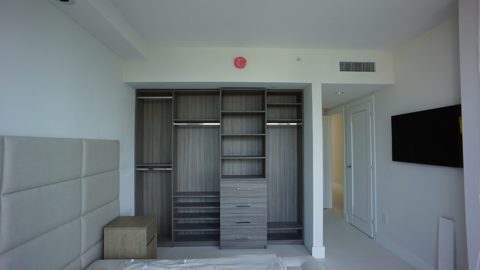 Ejemplo de vestidor contemporáneo grande con armarios con paneles lisos y puertas de armario de madera en tonos medios