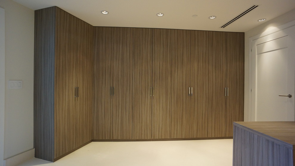 Diseño de vestidor contemporáneo grande con armarios con paneles lisos y puertas de armario de madera en tonos medios