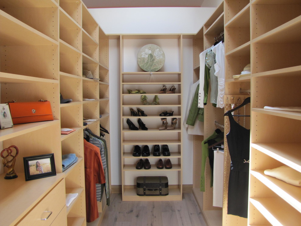 Foto di una cabina armadio unisex design di medie dimensioni con nessun'anta, ante in legno chiaro e pavimento in legno massello medio