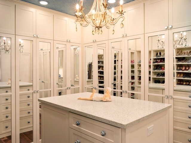 Photo of a large traditional walk-in wardrobe for women in Tampa with white cabinets, medium hardwood flooring and shaker cabinets.
