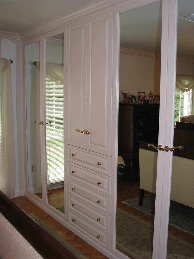 Diseño de armario vestidor unisex clásico grande con armarios con paneles con relieve, puertas de armario blancas, moqueta y suelo beige