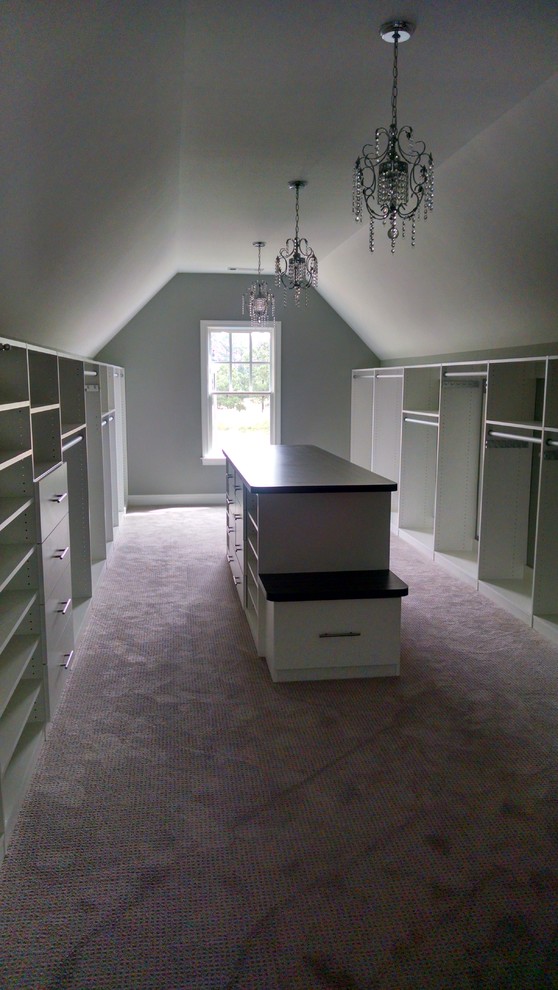 This is an example of an expansive classic gender neutral dressing room in Atlanta with open cabinets, white cabinets and carpet.