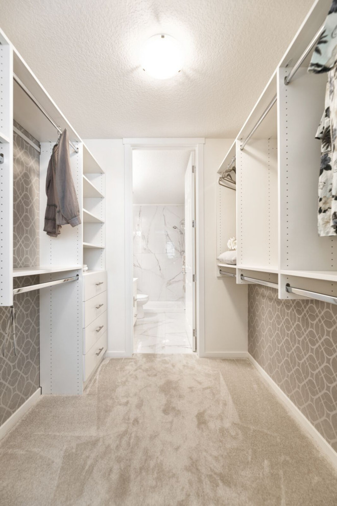 Immagine di una cabina armadio unisex minimal con ante lisce, ante bianche, moquette e pavimento beige